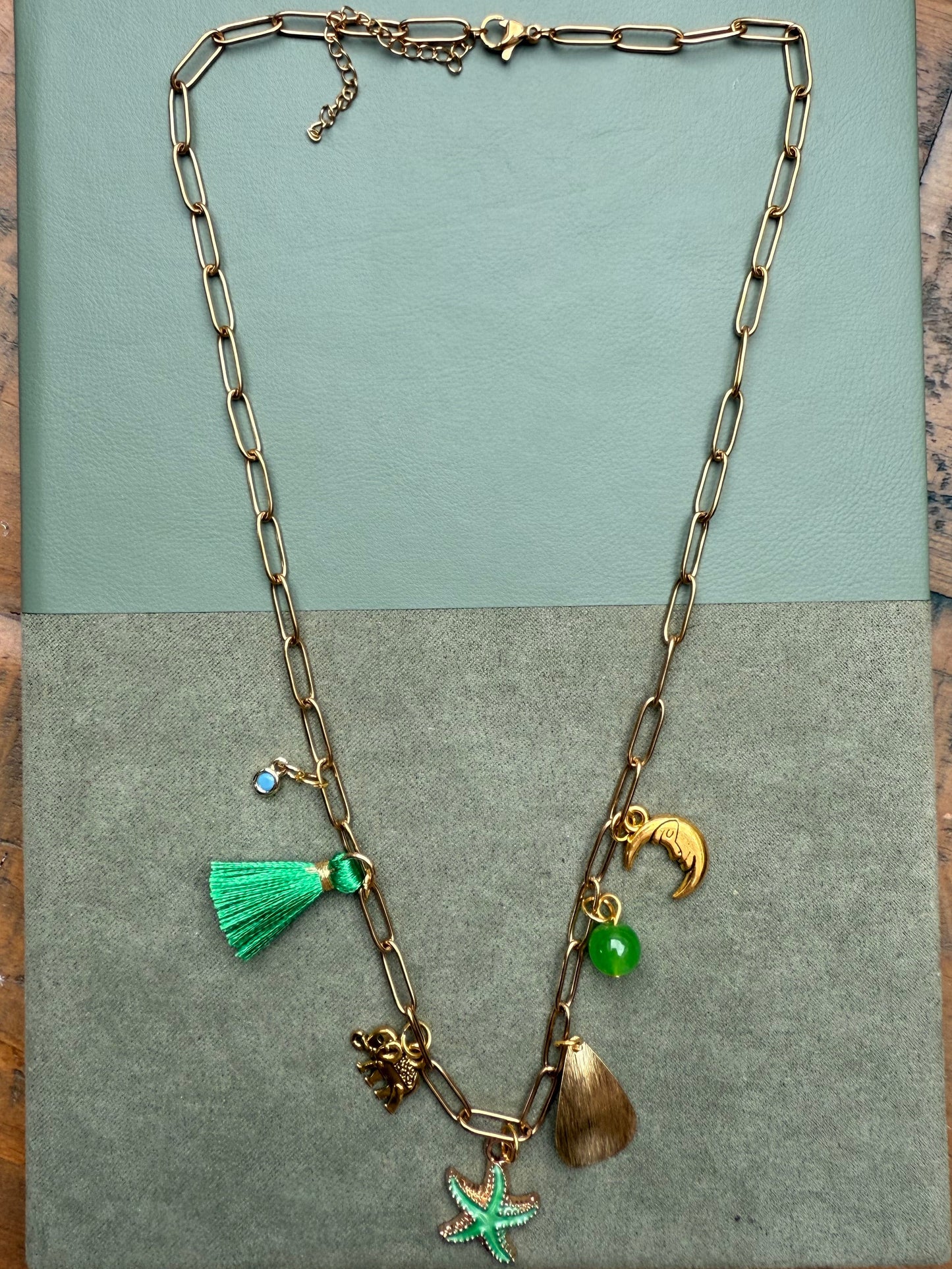 Necklace with various charms on a green surface