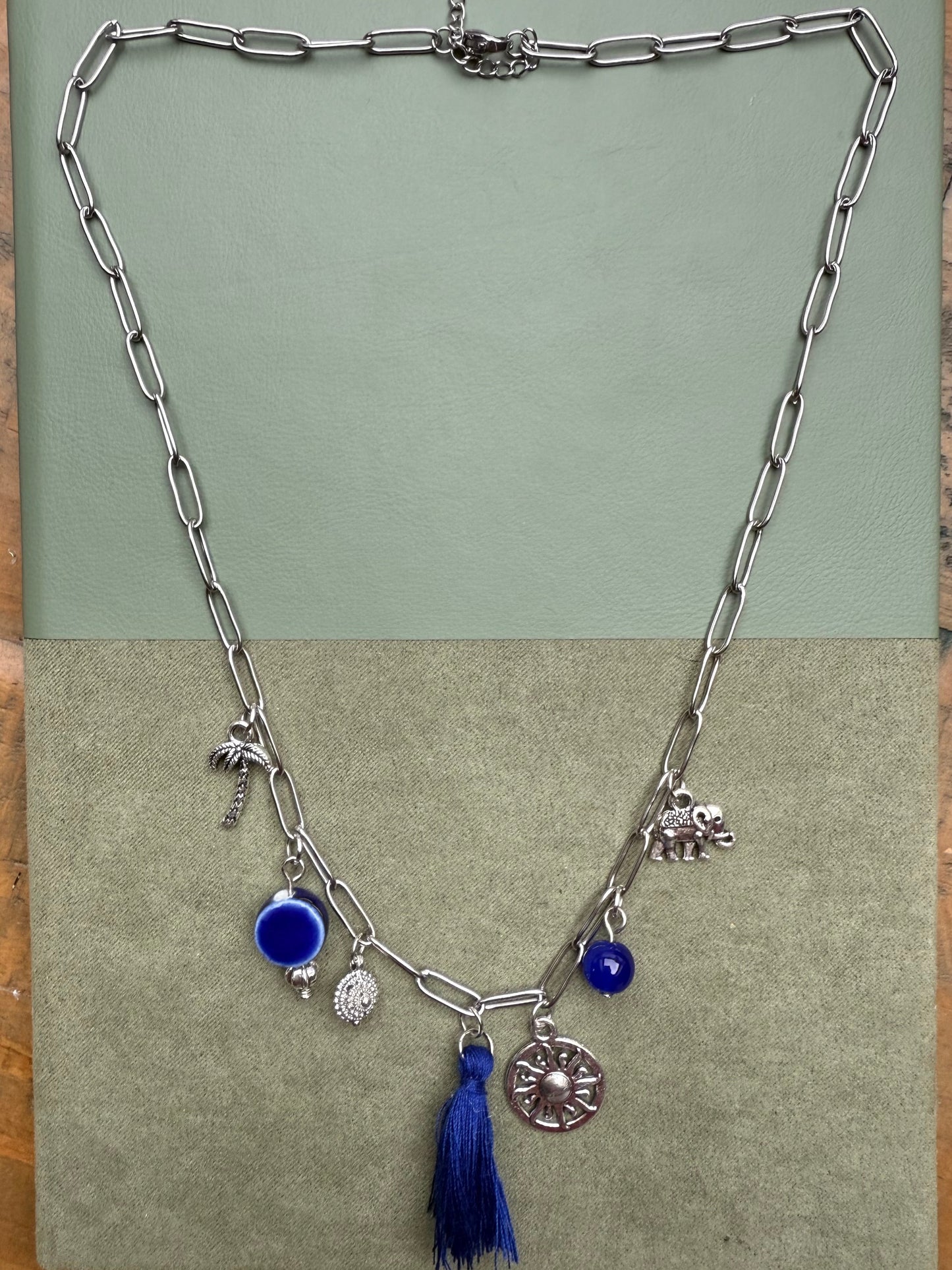Necklace with charms on a green surface