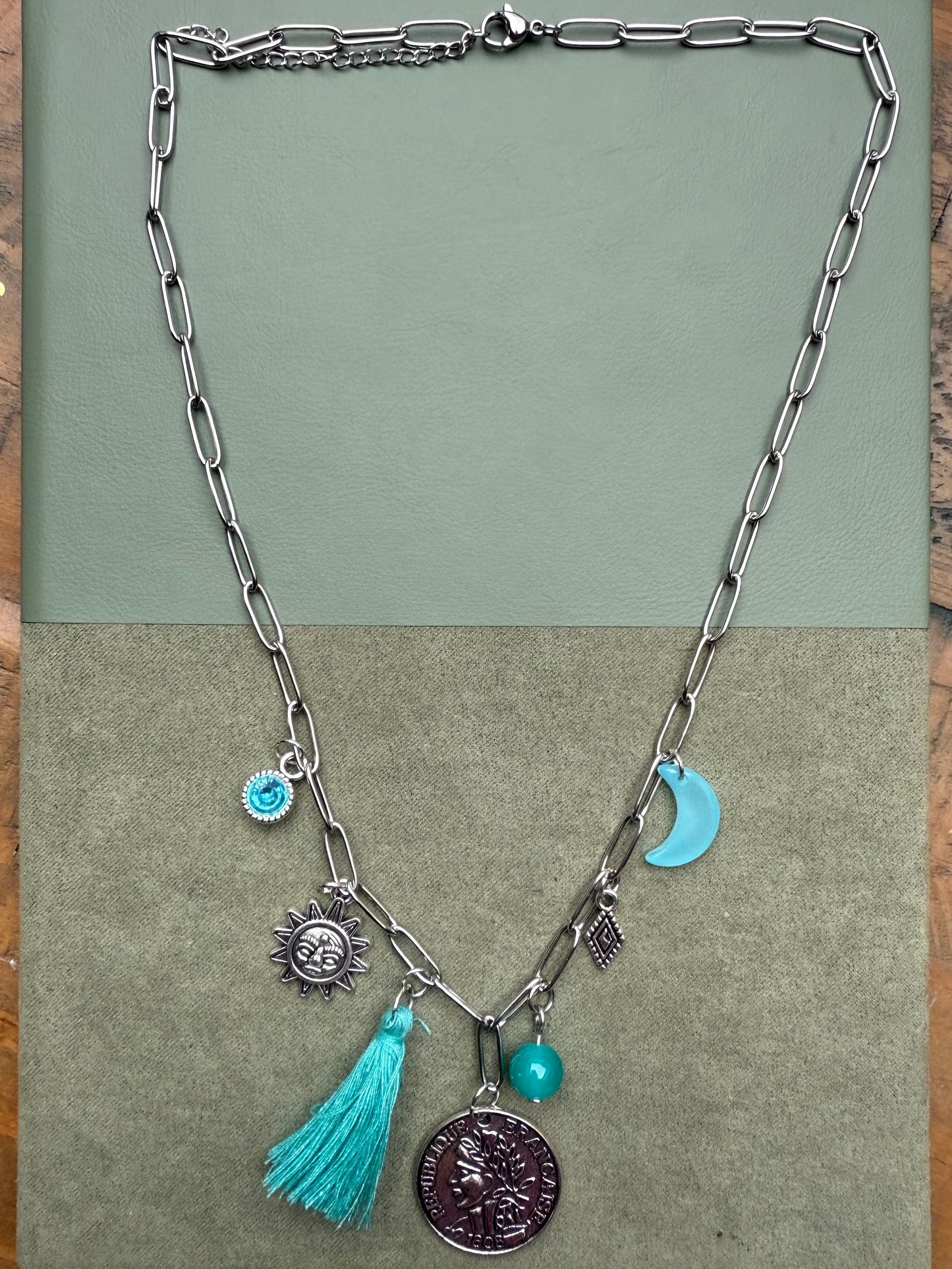Necklace with charms and tassel on a green background