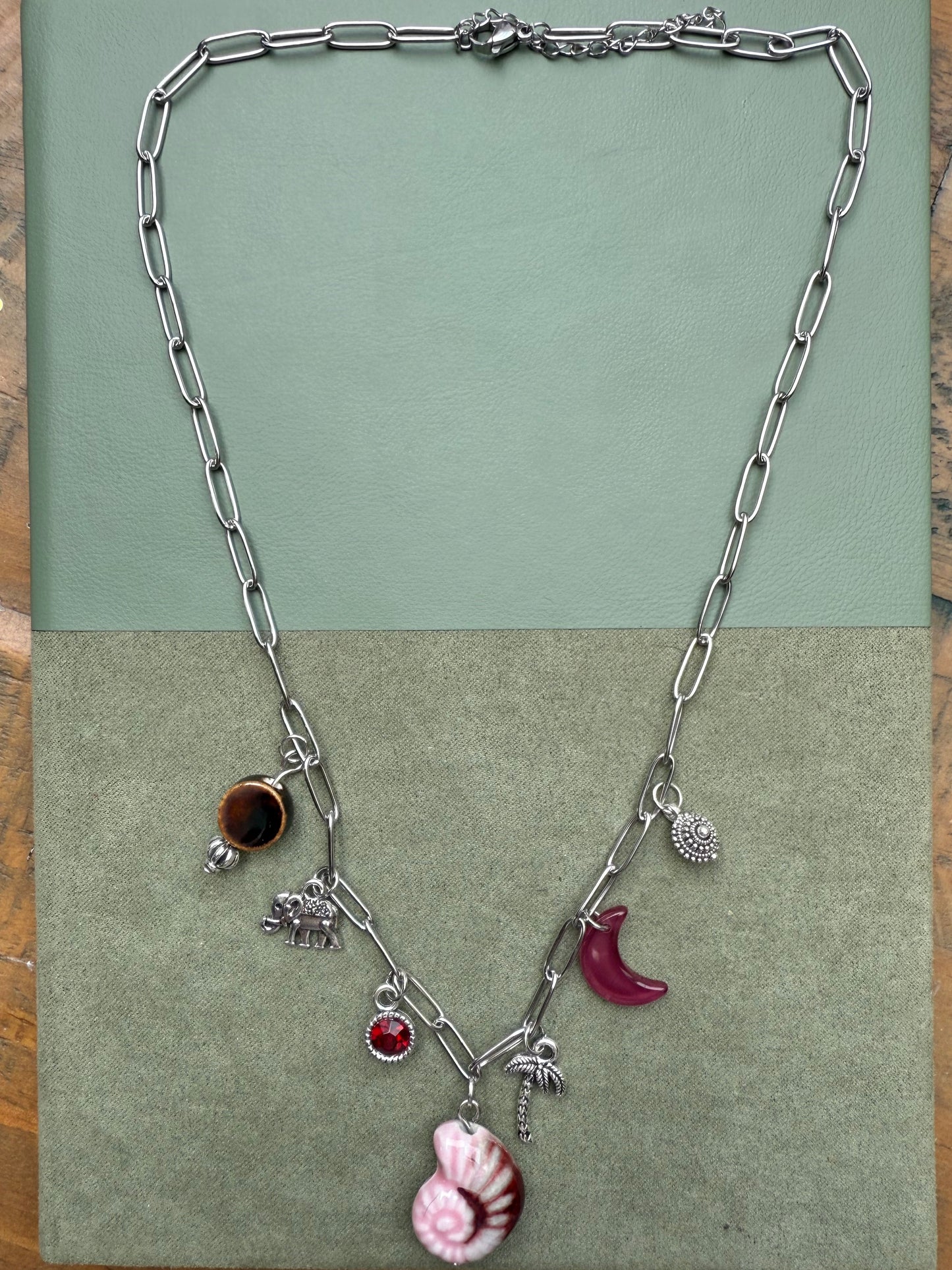Silver necklace with charms on a green card