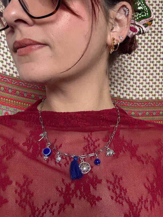 Person wearing glasses with a decorative headband and red lace garment