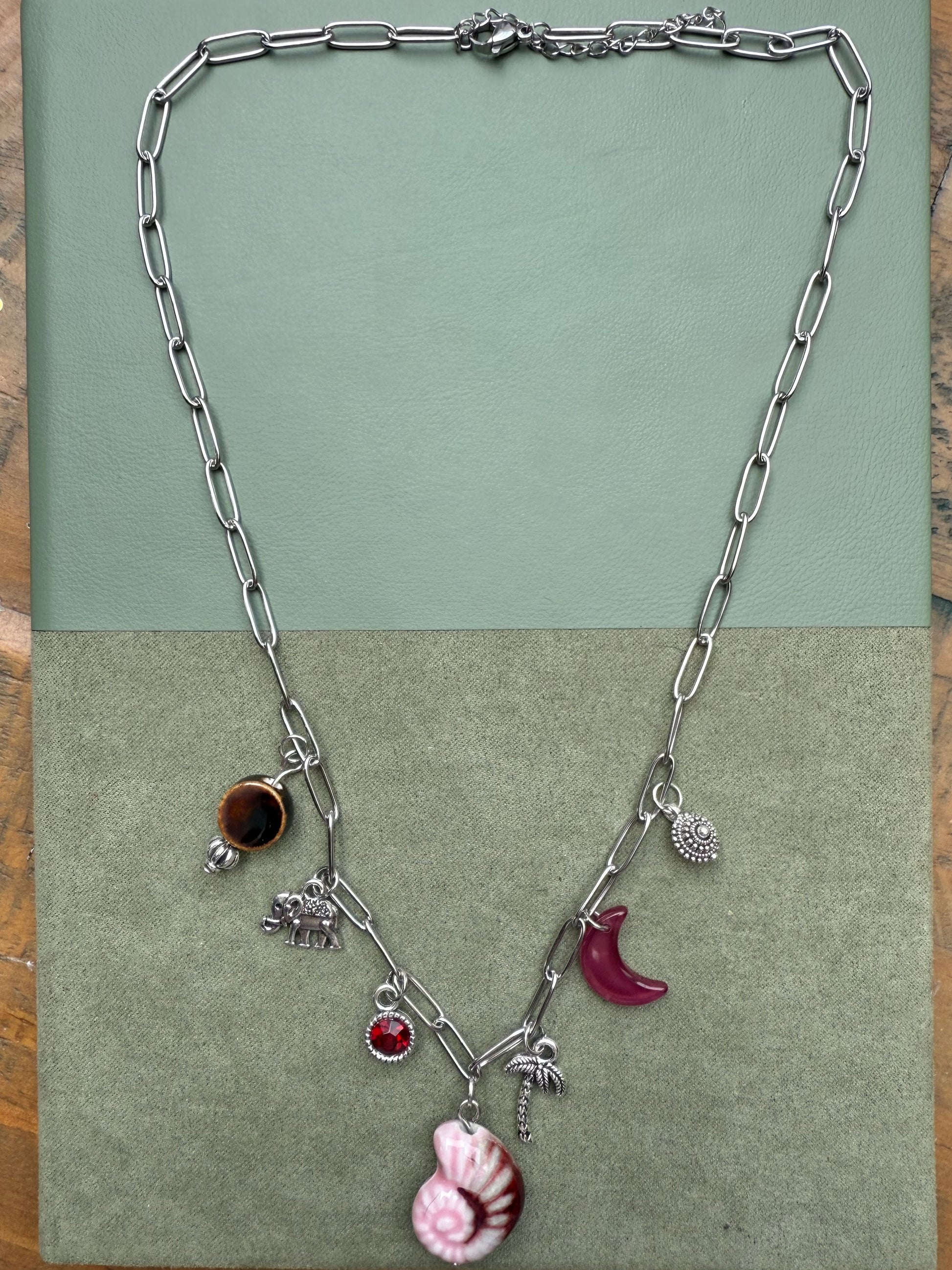 Silver necklace with charms on a green card